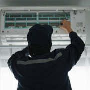 Asian mature woman air technician checking air conditioner.